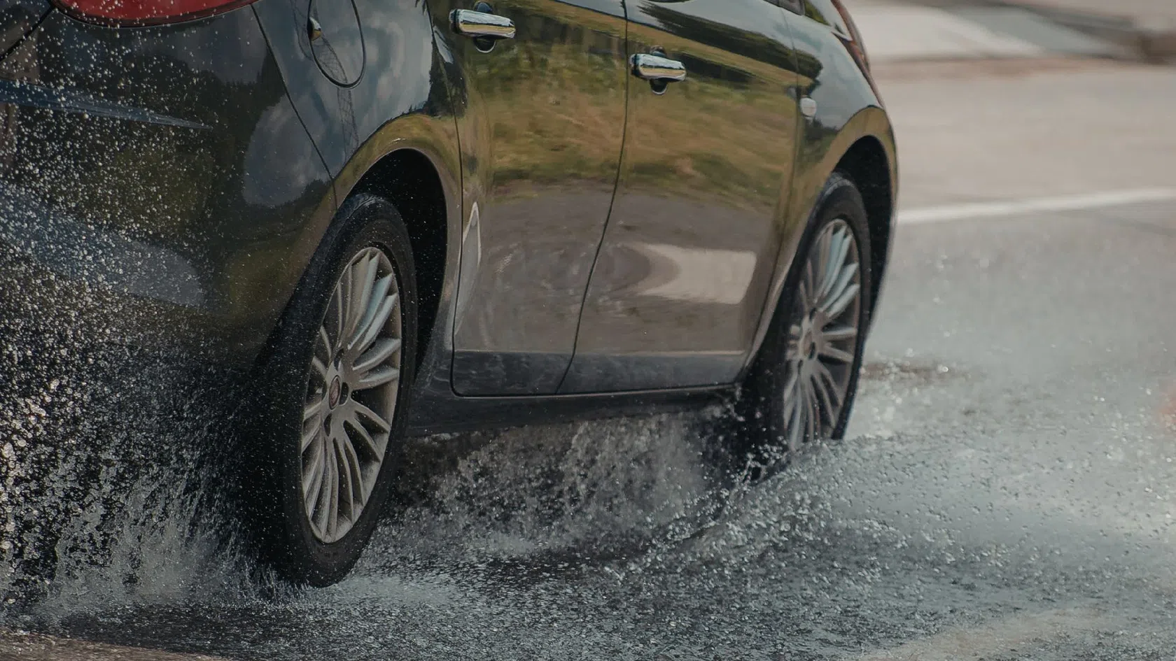 Carro a passar por poça durante tempestade